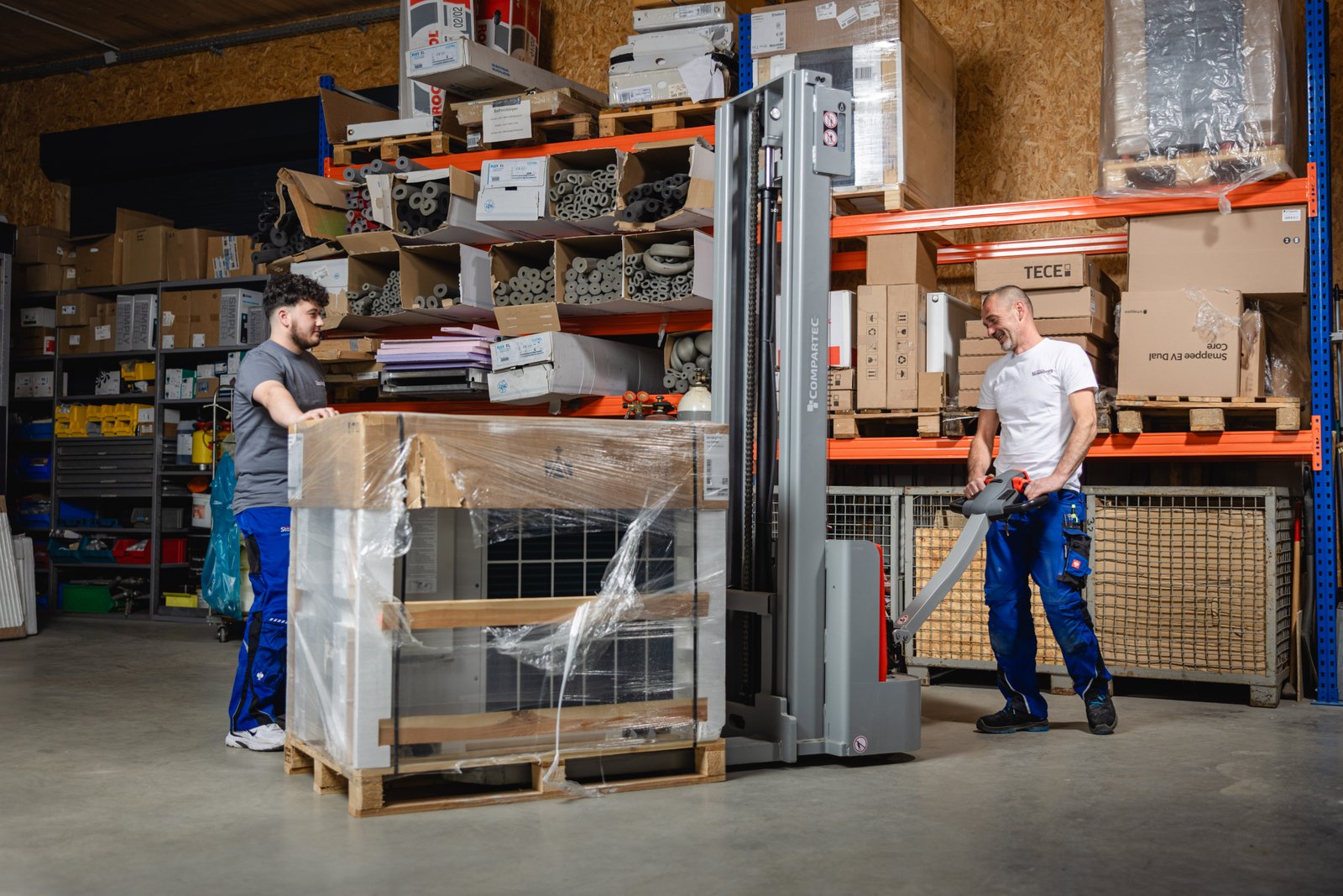 Zwei Handwerker bewegen eine Wärmepumpe